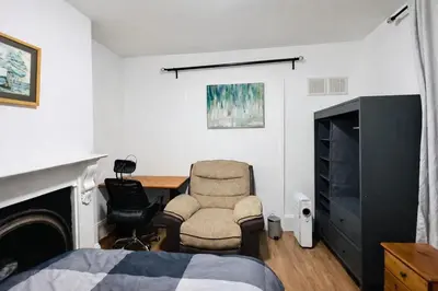 a bedroom with a bed and a chair and a desk at landvue stays, The Colchester town White House 4 bed 2 bath! in Mundon