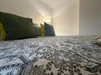 a bed with a black and white comforter and pillows at BMC Serene Spacious 1BR Flat in Enfield