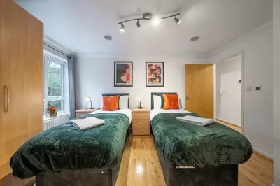 a bedroom with two beds with green covers at Bishops Stortford 2 Bed Flat - Free Parking - STN in Bishops Stortford