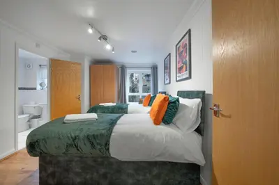 a bedroom with two beds and a bathroom at Bishops Stortford 2 Bed Flat - Free Parking - STN in Bishops Stortford