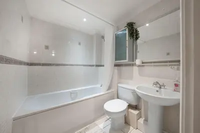 a white bathroom with a toilet and a sink at Bishops Stortford 2 Bed Flat - Free Parking - STN in Bishops Stortford