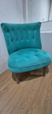 a blue couch sitting on top of a wooden floor at The Orchard's Nook Treehouse in Cottenham