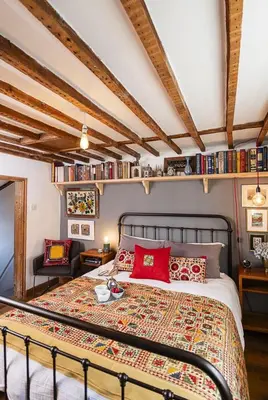 a bedroom with a large bed with red pillows at 4 Angel Lane in Woodbridge