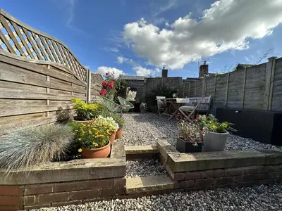 a garden with potted plants and a wooden fence at 4 Angel Lane in Woodbridge