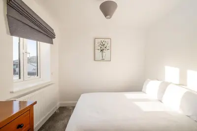 a white bedroom with a bed and a window at Dray Cottage, Leiston, near Sizewell - Ideal for a short or long term corporate lets - Managed by Aldeburgh Coastal Cottages in Leiston