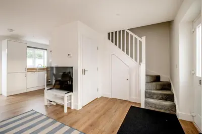 a living room with a staircase and a tv at Dray Cottage, Leiston, near Sizewell - Ideal for a short or long term corporate lets - Managed by Aldeburgh Coastal Cottages in Leiston