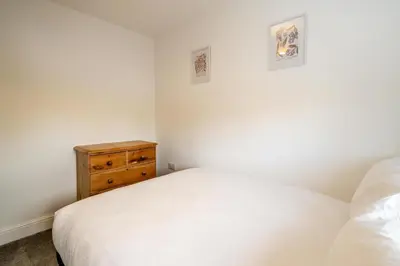 a bedroom with a white bed and a wooden dresser at Dray Cottage, Leiston, near Sizewell - Ideal for a short or long term corporate lets - Managed by Aldeburgh Coastal Cottages in Leiston