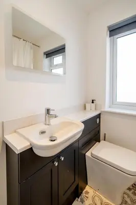 a bathroom with a sink and a toilet and a mirror at Dray Cottage, Leiston, near Sizewell - Ideal for a short or long term corporate lets - Managed by Aldeburgh Coastal Cottages in Leiston