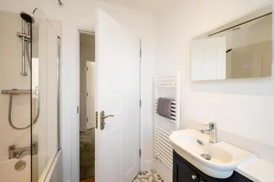 a white bathroom with a sink and a shower at Dray Cottage, Leiston, near Sizewell - Ideal for a short or long term corporate lets - Managed by Aldeburgh Coastal Cottages in Leiston
