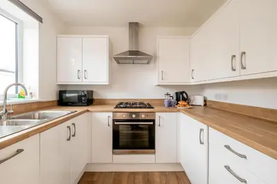 a kitchen with white cabinets and a sink at Dray Cottage, Leiston, near Sizewell - Ideal for a short or long term corporate lets - Managed by Aldeburgh Coastal Cottages in Leiston
