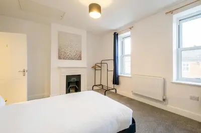 a white bedroom with a bed and a fireplace at 1 Volunteer House, Leiston, near Sizewell - Ideal for a short or long term corporate lets - Managed by Aldeburgh Coastal Cottages in Leiston