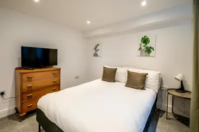 a bedroom with a bed and a tv on a dresser at 1 Volunteer House, Leiston, near Sizewell - Ideal for a short or long term corporate lets - Managed by Aldeburgh Coastal Cottages in Leiston