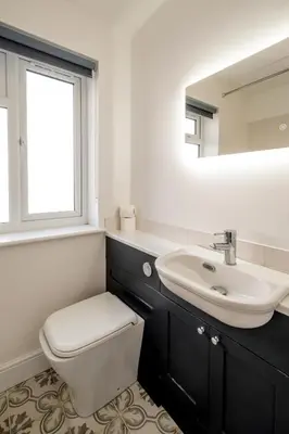 a bathroom with a toilet and a sink and a mirror at Garden Cottage, Leiston, near Sizewell - Ideal for a short or long term corporate lets - Managed by Aldeburgh Coastal Cottages in Leiston