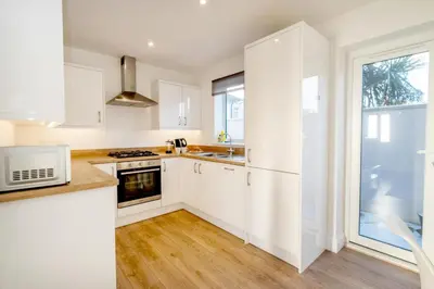 a kitchen with white cabinets and a window at Garden Cottage, Leiston, near Sizewell - Ideal for a short or long term corporate lets - Managed by Aldeburgh Coastal Cottages in Leiston