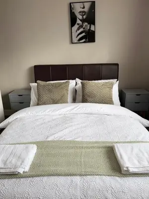 a bedroom with a large white bed with two night stands at 3 bed house, sleeps 5, 8 mins to Harold wood Station in Havering atte Bower