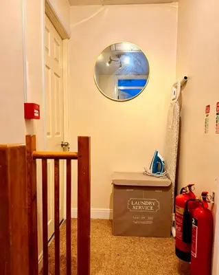 a hallway with a round mirror on the wall at 3 bed house, sleeps 5, 8 mins to Harold wood Station in Havering atte Bower