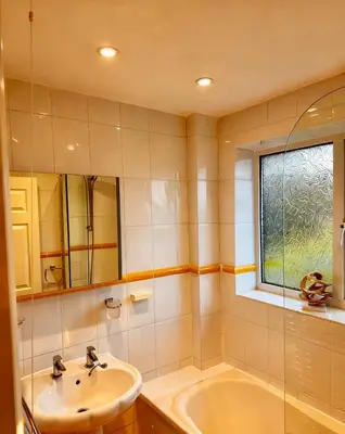 a bathroom with a sink and a tub and a window at 3 bed house, sleeps 5, 8 mins to Harold wood Station in Havering atte Bower