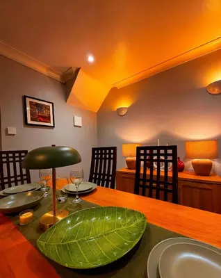 a dining room with a table with a green leaf on it at 3 bed house, sleeps 5, 8 mins to Harold wood Station in Havering atte Bower