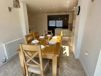 a wooden dining room table with chairs and a kitchen at Detached, 4 Double Rooms, 2 En-Suites, 5 Car Parking in Lexden