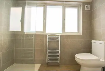 a bathroom with a toilet and a window at Margrets Crescent in Leiston