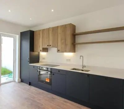a kitchen with a sink and a stove top oven at Margrets Crescent in Leiston