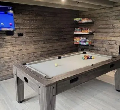 a pool table in a room with a tv at Margrets Crescent in Leiston