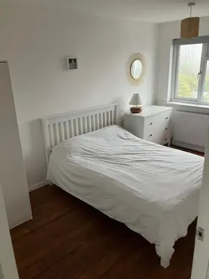 a bedroom with a white bed and a window at 4 De Vere Lane, Wivenhoe in Wivenhoe