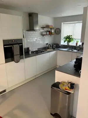 a kitchen with white cabinets and a stove top oven at 4 De Vere Lane, Wivenhoe in Wivenhoe