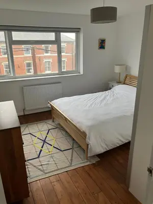 a bedroom with a bed and a large window at 4 De Vere Lane, Wivenhoe in Wivenhoe