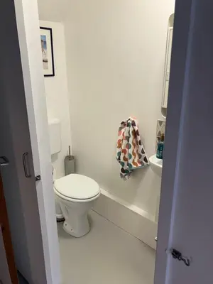 a white bathroom with a toilet and a sink at 4 De Vere Lane, Wivenhoe in Wivenhoe
