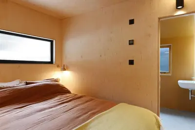 a bedroom with a bed and a sink and a window at Gazebo Lodge in Martlesham