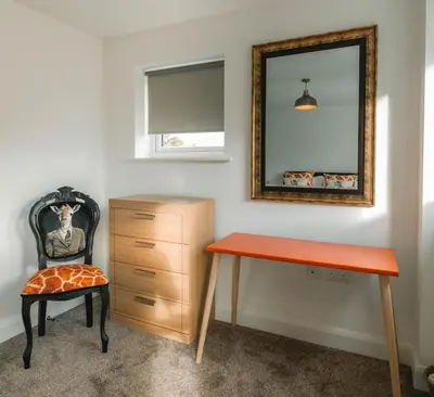 a bedroom with a desk and a chair and a mirror at Norwich New 3 Bedroom Townhouse Close to NNUH UEA
