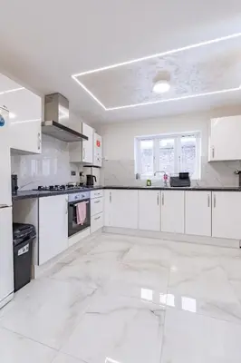 a large white kitchen with white cabinets and appliances at Hamlet Hideaway Sleeps 14 Off Street Parking - Pass the Keys in Westcliff On Sea