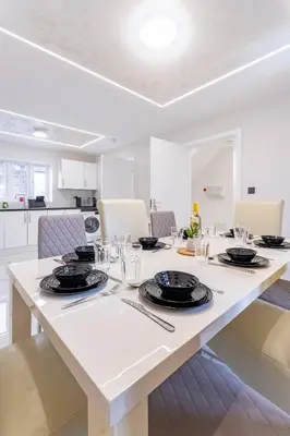 a large white table with plates and glasses on it at Hamlet Hideaway Sleeps 14 Off Street Parking - Pass the Keys in Westcliff On Sea