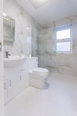 a white bathroom with a toilet and a sink at Hamlet Hideaway Sleeps 14 Off Street Parking - Pass the Keys in Westcliff On Sea