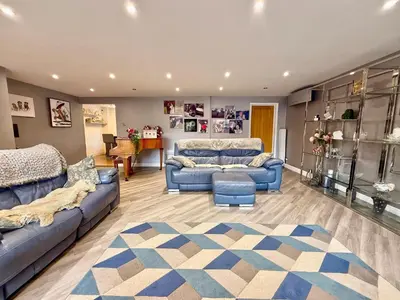 a living room with two blue couches and a rug at Charming 3 bedroom house in Chelmsford in Chelmsford