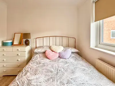 a bedroom with a bed with three pillows on it at Charming 3 bedroom house in Chelmsford in Chelmsford