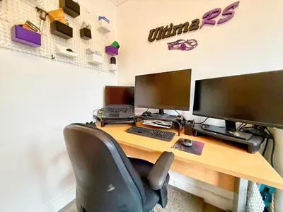 a desk with two computer monitors and a keyboard at Charming 3 bedroom house in Chelmsford in Chelmsford