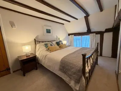 a bedroom with a large bed and a window at Pretty Cottage in Harleston, Norfolk, dog friendly in Harleston