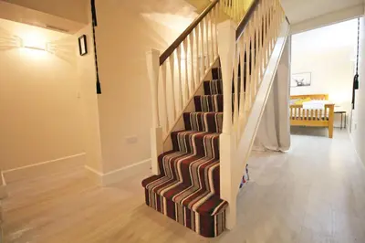a staircase in a living room with a stair case at Central 3 BR Home with Private Courtyard in Ely