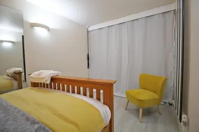 a bedroom with a yellow bed and a chair at Central 3 BR Home with Private Courtyard in Ely