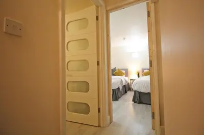 a hallway with a room with two beds and a mirror at Central 3 BR Home with Private Courtyard in Ely