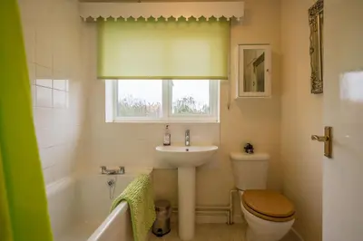 a bathroom with a sink and a toilet and a window at 1 Hall Farm Cottage, Aldeburgh in Aldeburgh
