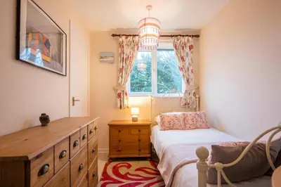 a bedroom with a bed and a dresser and a window at 1 Hall Farm Cottage, Aldeburgh in Aldeburgh