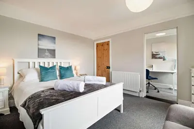 a bedroom with a white bed with blue pillows at 3 Bed in Felixstowe oc-s27808 in Felixstowe