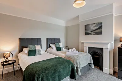 a bedroom with two beds and a fireplace at 3 Bed in Felixstowe oc-s27808 in Felixstowe