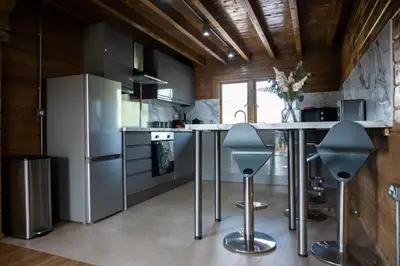 a kitchen with stainless steel appliances and a counter with stools at Owls Nest in Larling