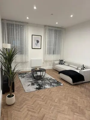 a living room with a couch and a table at Luxury Modern Apartment in Central Chelmsford in Chelmsford