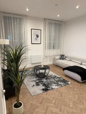a living room with a couch and a table at Luxury Modern Apartment in Central Chelmsford in Chelmsford
