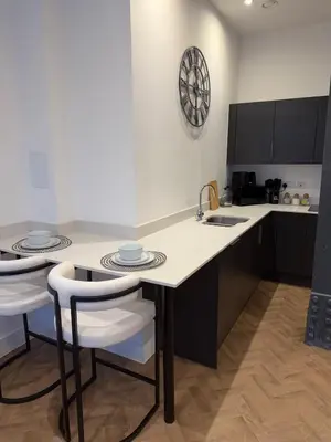 a kitchen with a table and two stools in it at Luxury Modern Apartment in Central Chelmsford in Chelmsford
